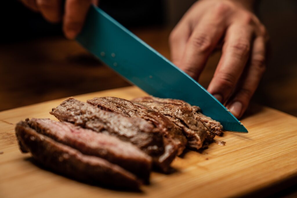 phases of dukan diet. A knife cutting meat on a cutting board.